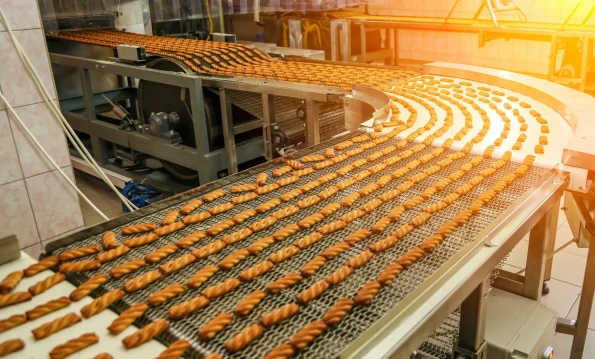 Biscuit production line in a bustling factory showcasing an array of freshly baked treats on the conveyor belt