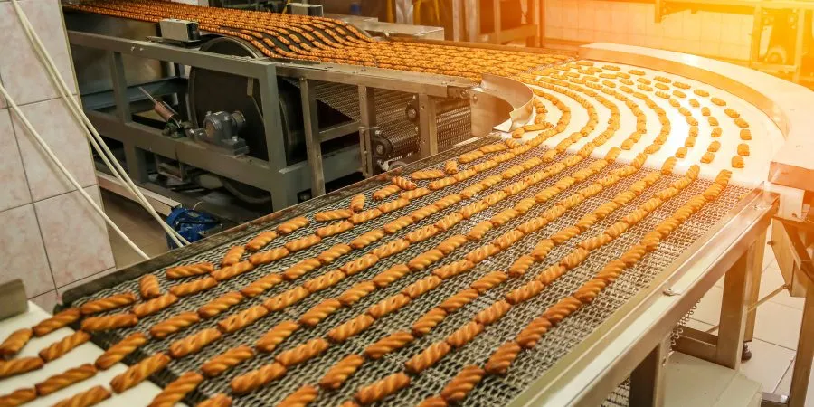 Biscuit production line in a bustling factory showcasing an array of freshly baked treats on the conveyor belt