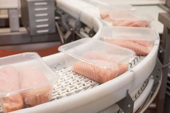 Factory for the production of food from meat.Production line with packaging .Conveyor Belt Food.Food products meat chicken in plastic packaging on the conveyor.