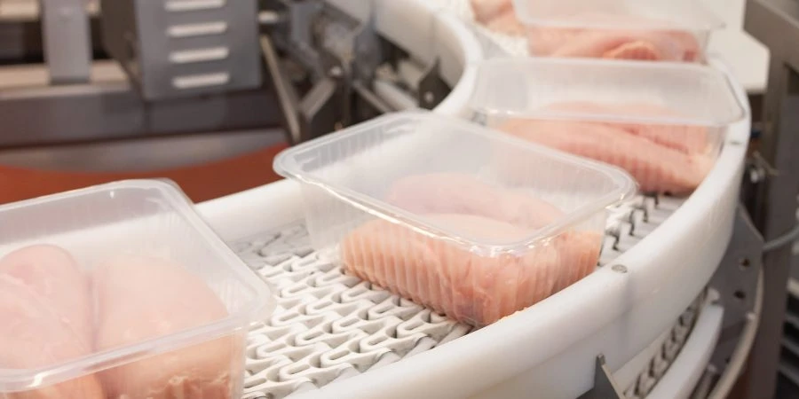 Factory for the production of food from meat.Production line with packaging .Conveyor Belt Food.Food products meat chicken in plastic packaging on the conveyor.